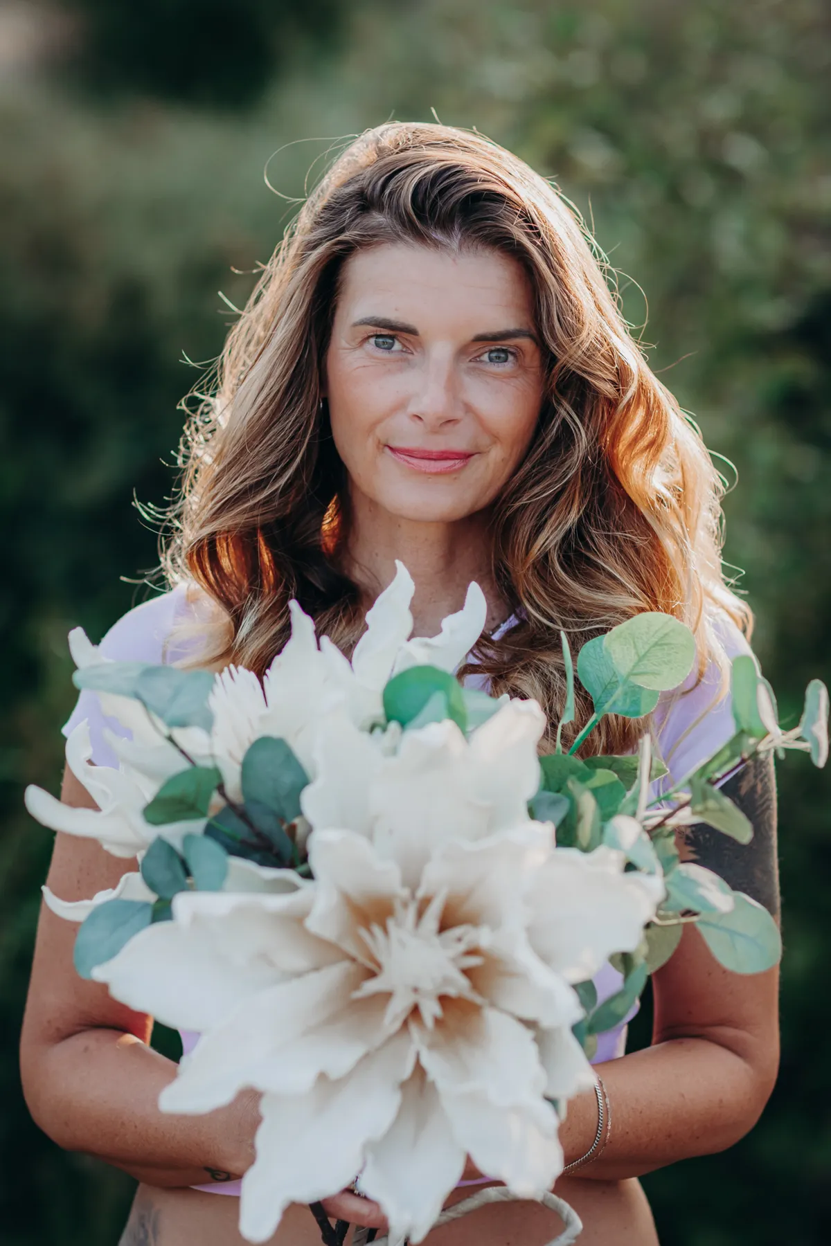Alexandra Kohler mit großem hellen Blumenstrauß, lächelt in die Kamera